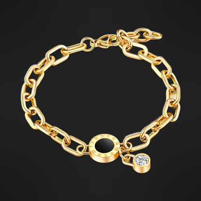 Oval-link bracelet in PVD gold over 316L stainless steel with a black inlaid disc and a cubic zirconia drop, on a black ground