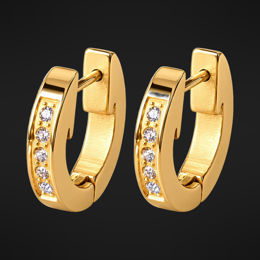 Pave Huggie Hoops in PVD gold over 316L stainless steel set with cubic zirconia, on a black ground