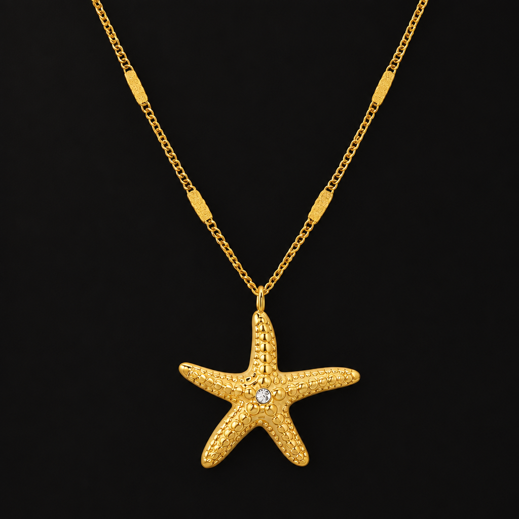 Starfish Pendant Necklace in PVD gold over 316L stainless steel, textured starfish pendant on a fine chain, on a black ground