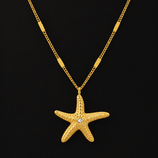 Starfish Pendant Necklace in PVD gold over 316L stainless steel, textured starfish pendant on a fine chain, on a black ground