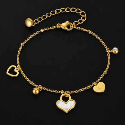 Heart Charm Bracelet in PVD gold over 316L stainless steel, gold and white heart charms on a fine chain, on a black ground